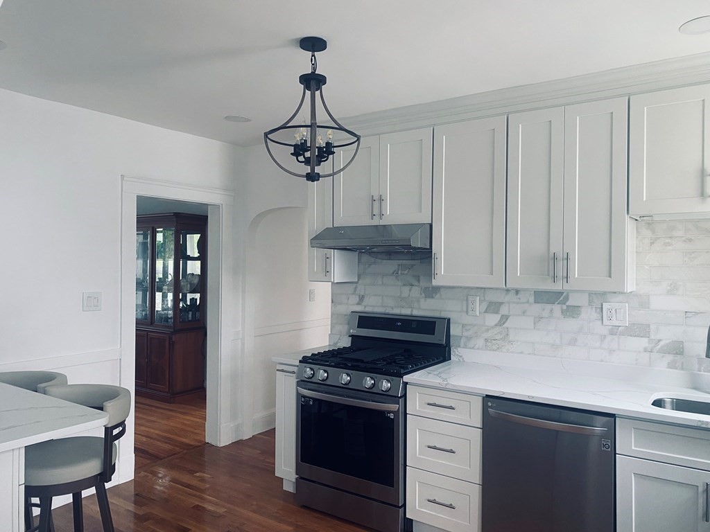16 Libbey Street Boston, MA 02132 - Photo 8 of 41 a kitchen with stainless steel appliances a stove and white cabinets