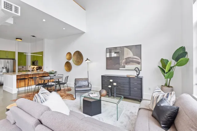 a living room with furniture a rug and a painting