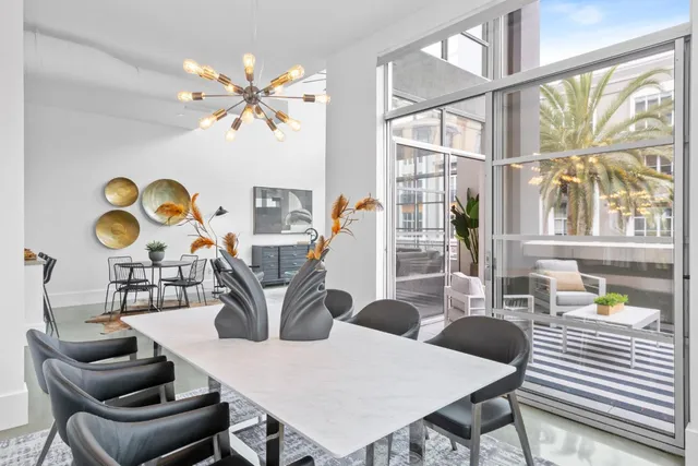 a view of a dining room with furniture a rug and wooden floor