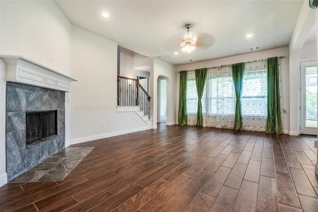 an empty room with wooden floor and fireplace