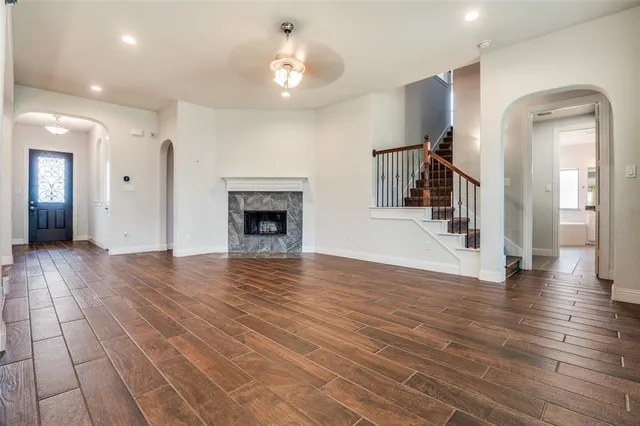 an empty room with wooden floor and a fireplace