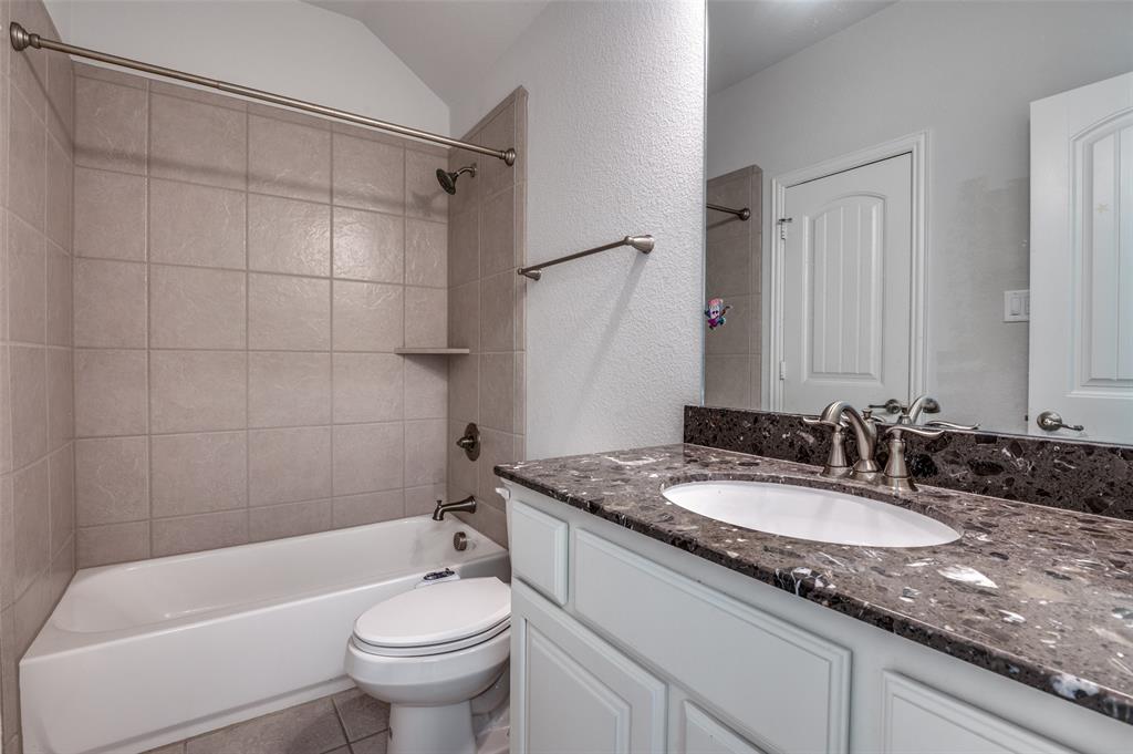 426 Summer Grove Drive Midlothian, TX 76065 - Photo 22 of 25 a bathroom with a granite countertop sink a toilet a mirror and bathtub