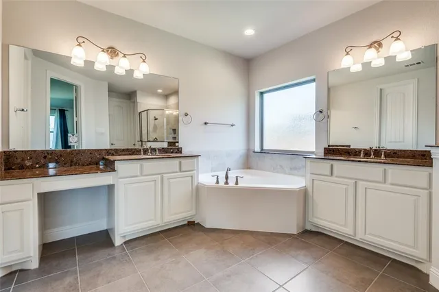 a bathroom with a sink vanity tub and a mirror
