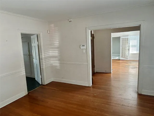 an empty room with wooden floor & closet area
