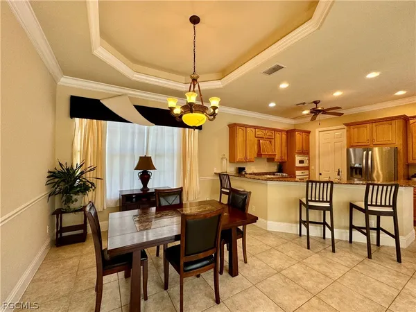 a view of a dining room and livingroom with furniture wooden floor a chandelier