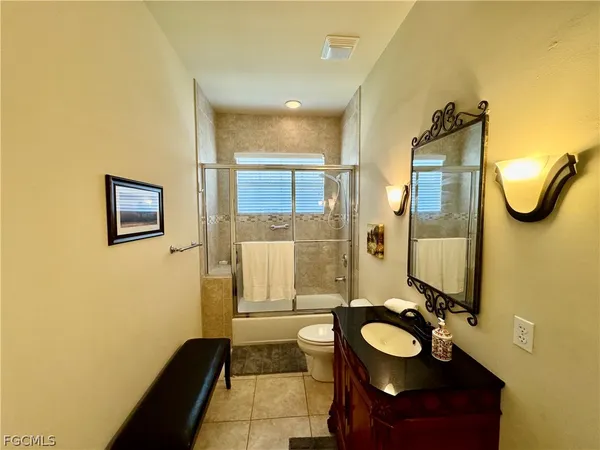 a bathroom with a sink mirror and tub