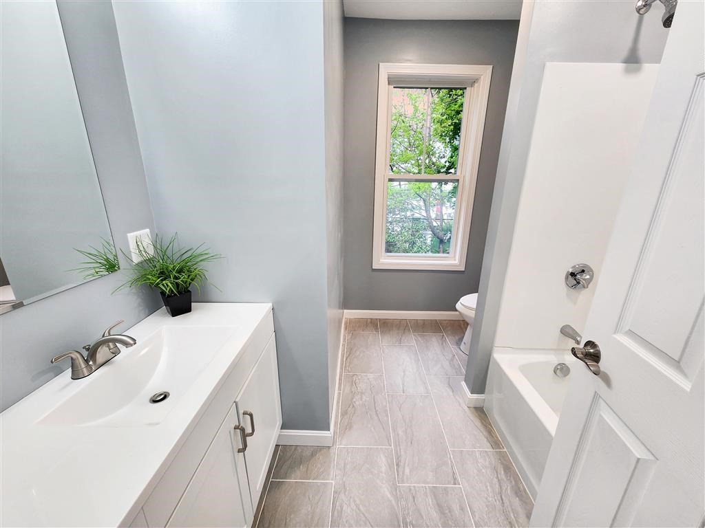 144 Rounds Street New Bedford, MA 02740 - Photo 15 of 20 a bathroom with a bathtub a sink and a window
