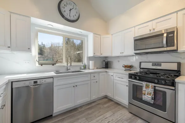a kitchen with stainless steel appliances granite countertop a stove and a microwave