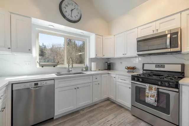 a kitchen with stainless steel appliances granite countertop a stove and a microwave