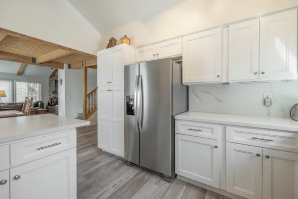 a kitchen with stainless steel appliances white cabinets and a refrigerator
