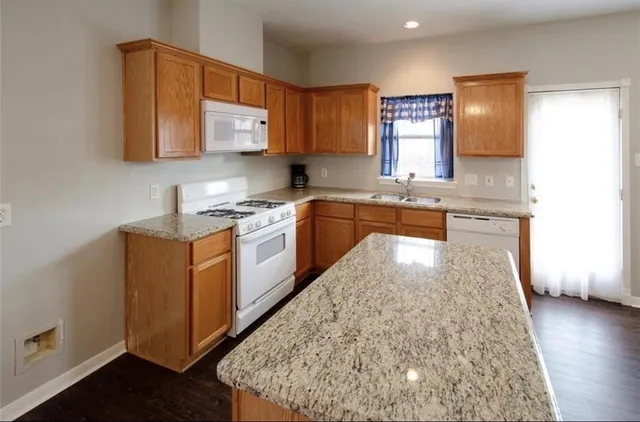 a kitchen with stainless steel appliances granite countertop wooden cabinets a sink and dishwasher