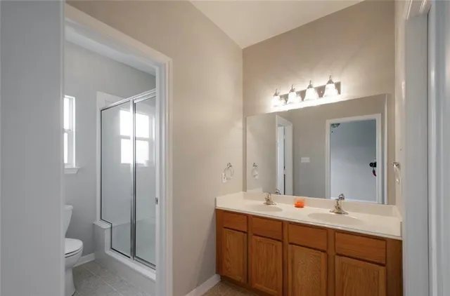 a bathroom with a double vanity sink and a toilet