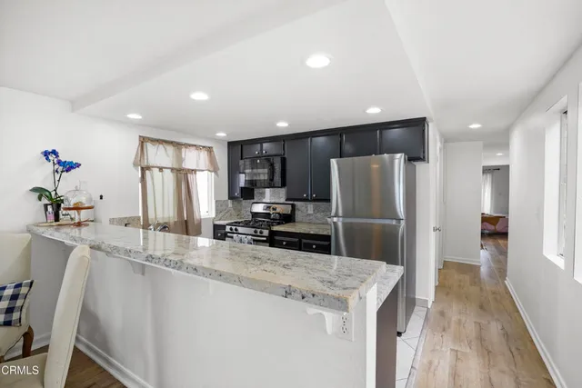 a kitchen with kitchen island a counter top space cabinets and stainless steel appliances