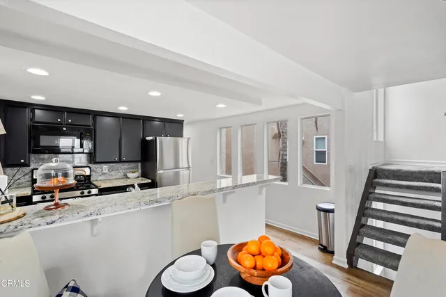 a kitchen with stainless steel appliances granite countertop a sink and a refrigerator
