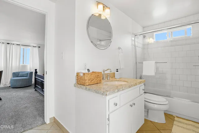 a bathroom with a granite countertop sink a mirror and a toilet