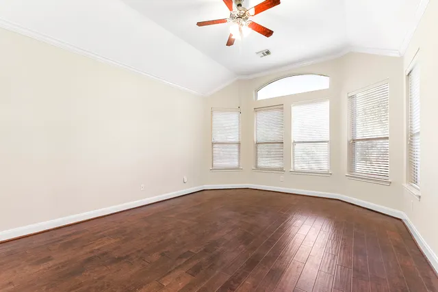 an empty room with wooden floor and window