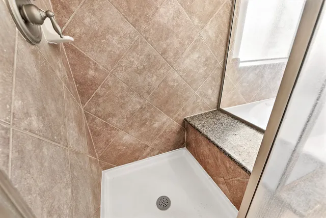 a bathroom with a granite countertop sink toilet and shower