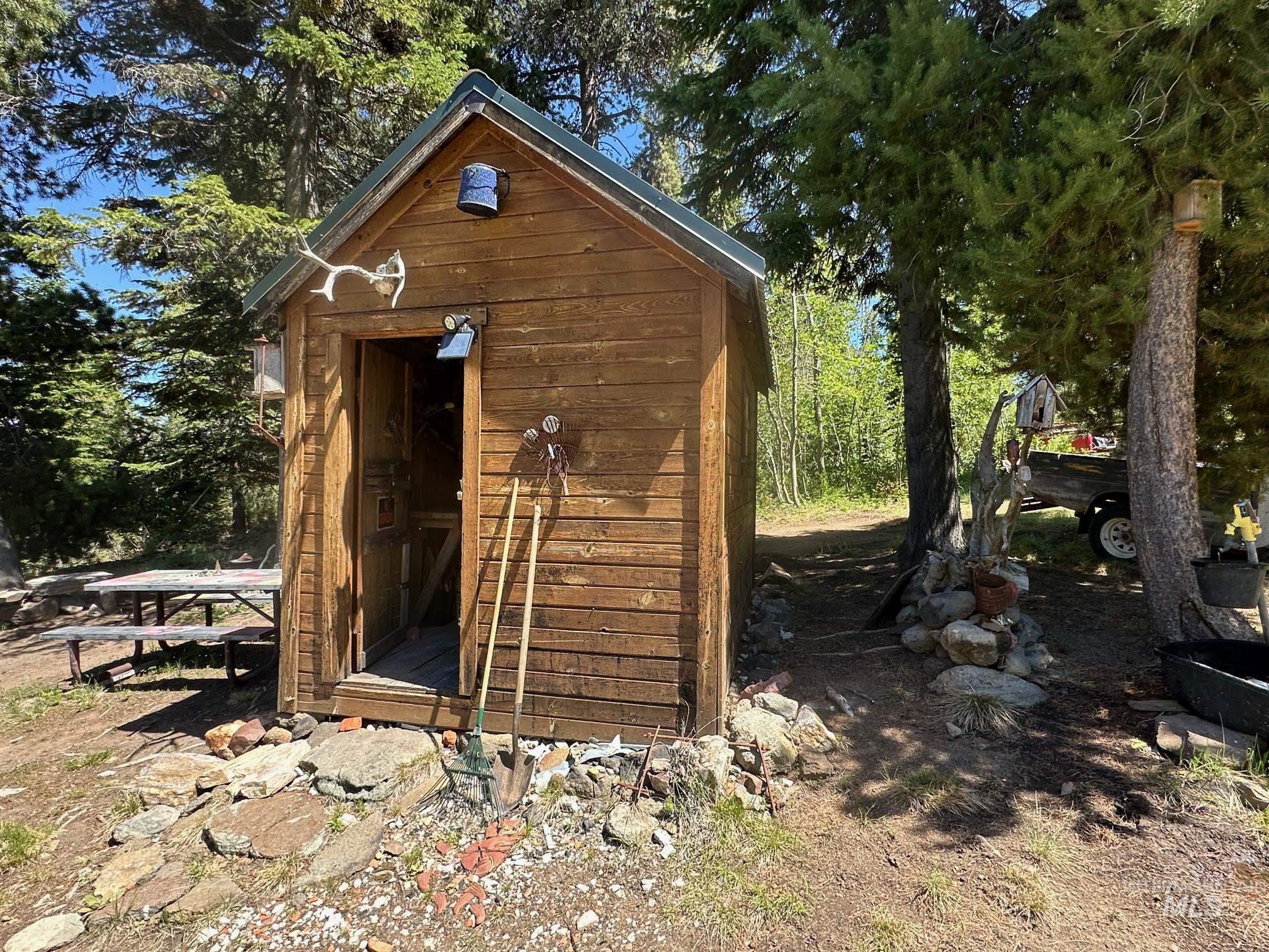 509 Deadline Road, Unit 2 Twin Falls, ID 83301 - Photo 27 of 28 Wood-sided structure with a dark green metal roof, set amidst mature trees