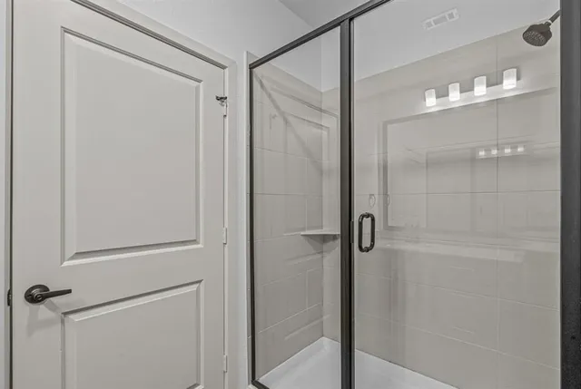 a bathroom with a glass shower door