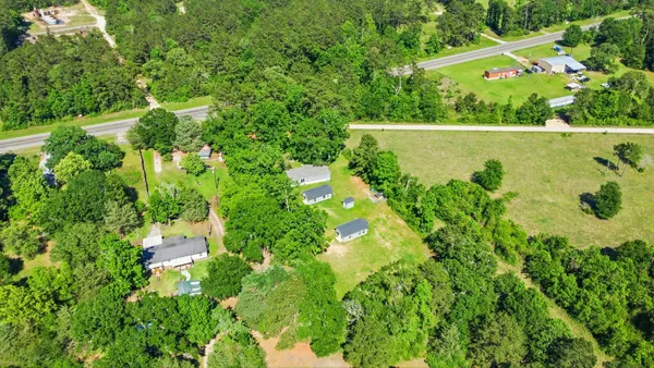 an aerial view of a residential houses with a yard and green space