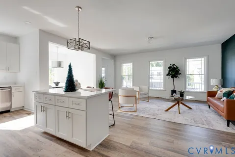 a living room with furniture a dining table and a potted plant