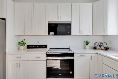 a kitchen with granite countertop white cabinets and white appliances