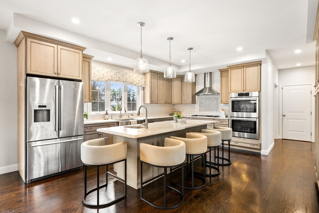 45 Saddleback Lane Canton, MA 02021 - Photo 2 of 42 a kitchen with stainless steel appliances a dining table chairs refrigerator and sink