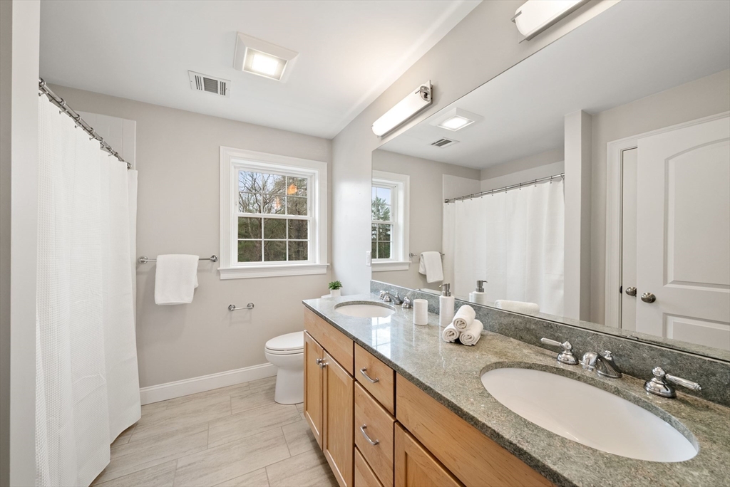 45 Saddleback Lane Canton, MA 02021 - Photo 25 of 42 a bathroom with a granite countertop double vanity sink a mirror and a bathtub