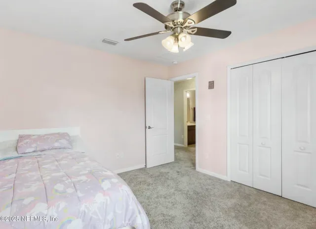 a view of a bedroom with closet and a ceiling fan