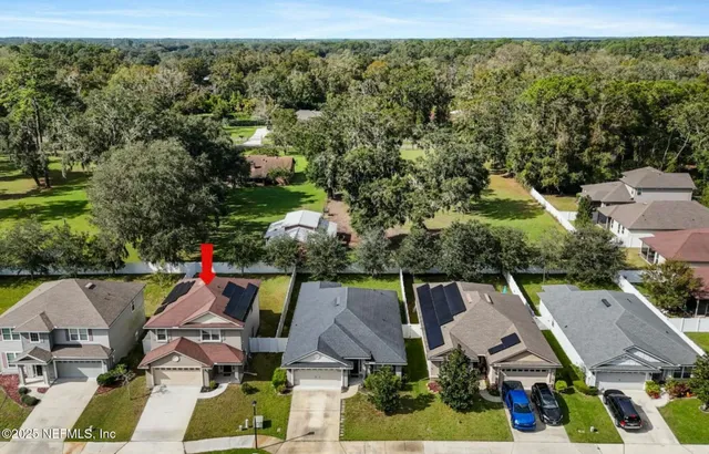 an aerial view of residential houses with outdoor space and swimming pool