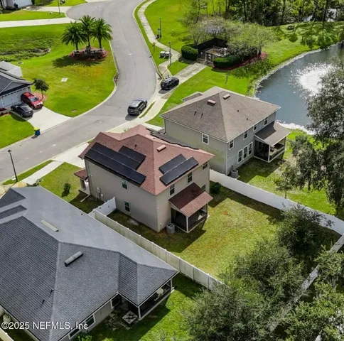an aerial view of a house with a garden and lake view