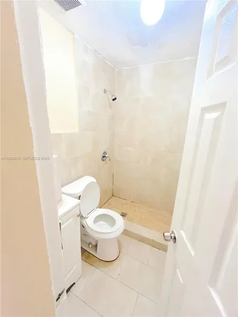 a white toilet sitting next to a bathroom sink and a mirror