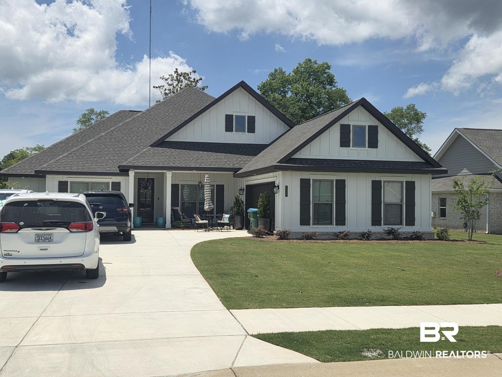 12151 Exbury Way Daphne, AL 36527 - Photo 1 of 51 Contemporary farmhouse-style residence featuring white vertical siding with dark trim accents