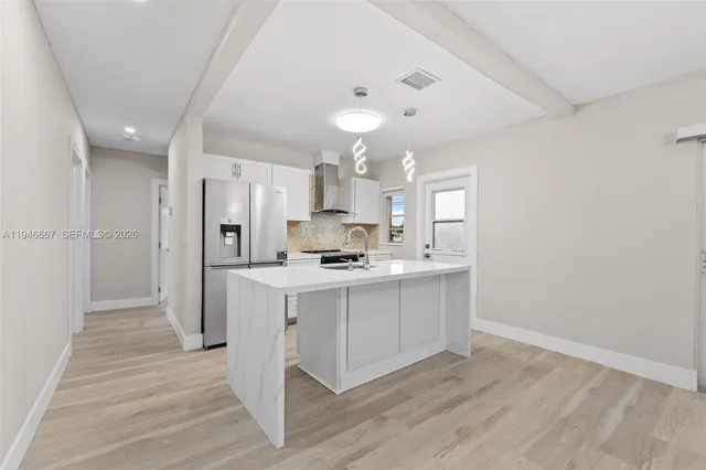 a large kitchen with a lot of counter space and wooden floor