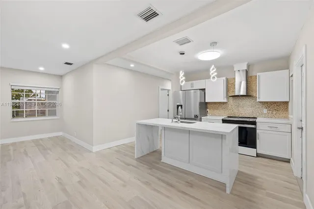 a kitchen with a sink cabinets stainless steel appliances and a window