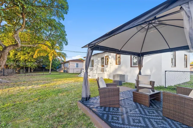 a view of an house with backyard and sitting area