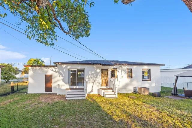 a view of a house with backyard and sitting area