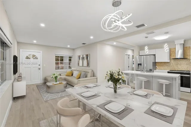 a living room with furniture a dining table and kitchen view