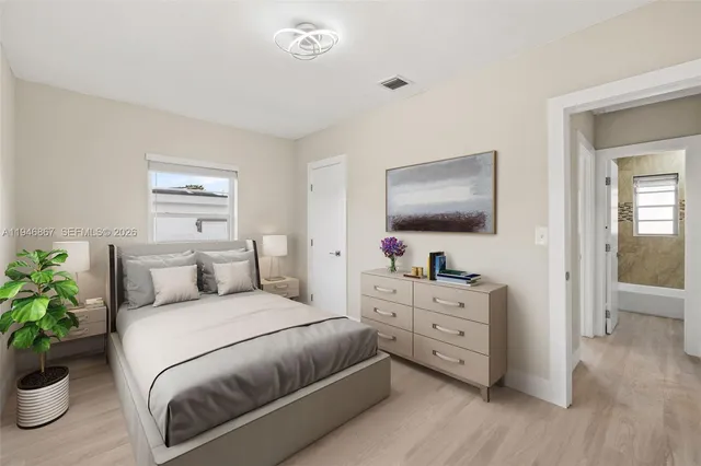 a bedroom with a large bed and a flat tv screen on dresser