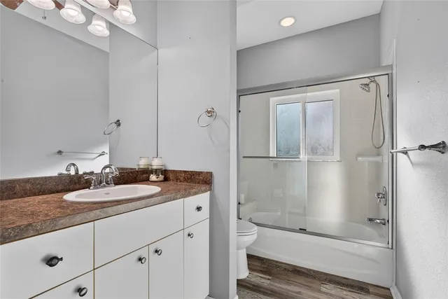 an empty room with wooden floor and window