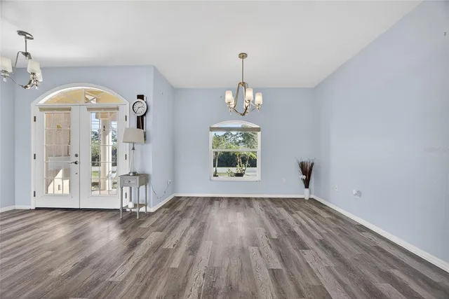 a kitchen with stainless steel appliances kitchen island granite countertop a dining table chairs and white cabinets