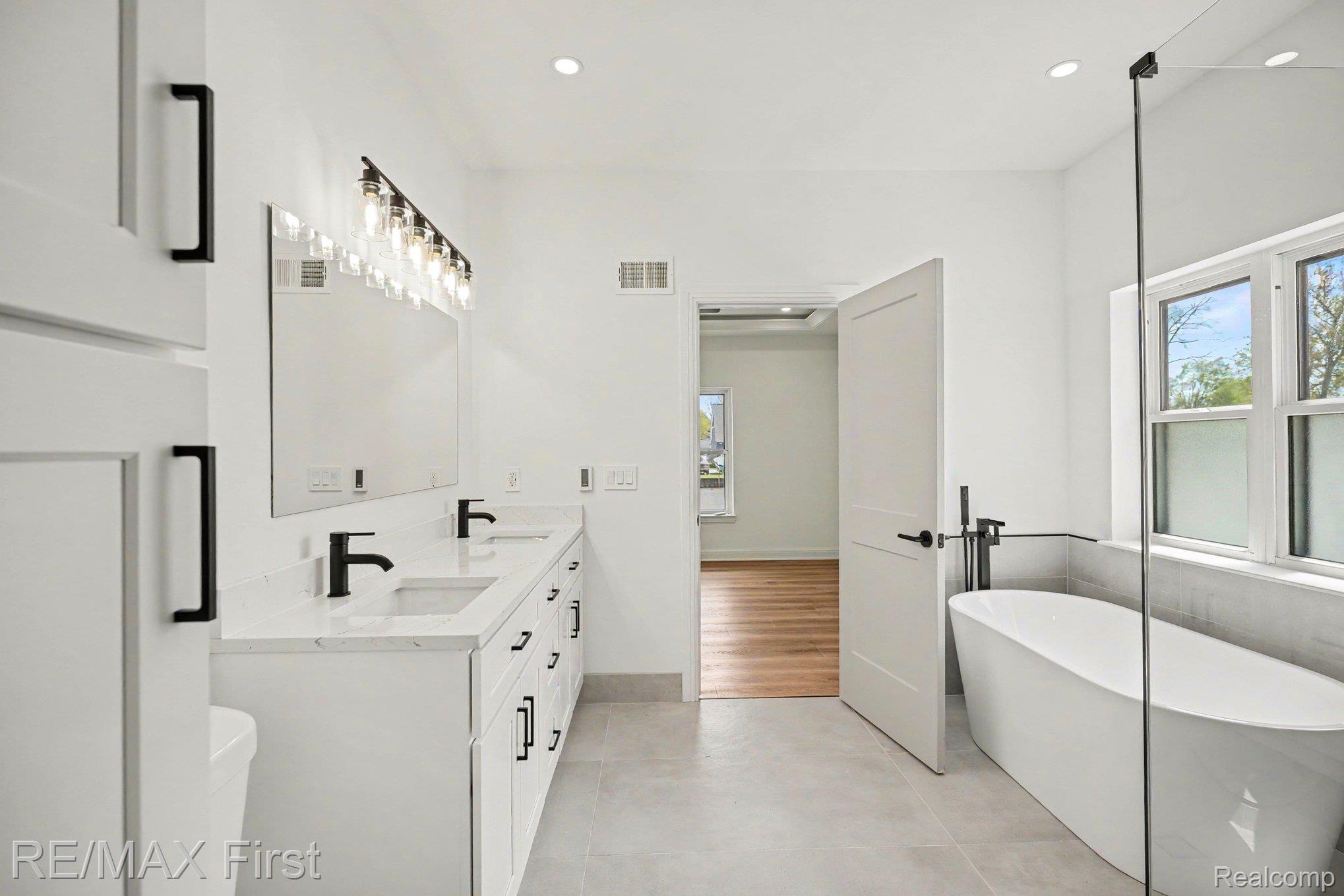7424 Dyke Road Algonac, MI 48001 - Photo 21 of 31 Bathroom with double vanity, a soaking tub, and recessed lighting
