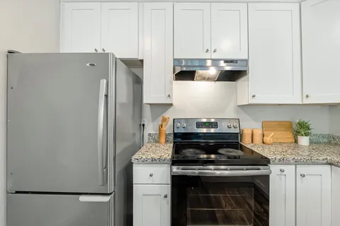 a stove top oven sitting inside of a kitchen