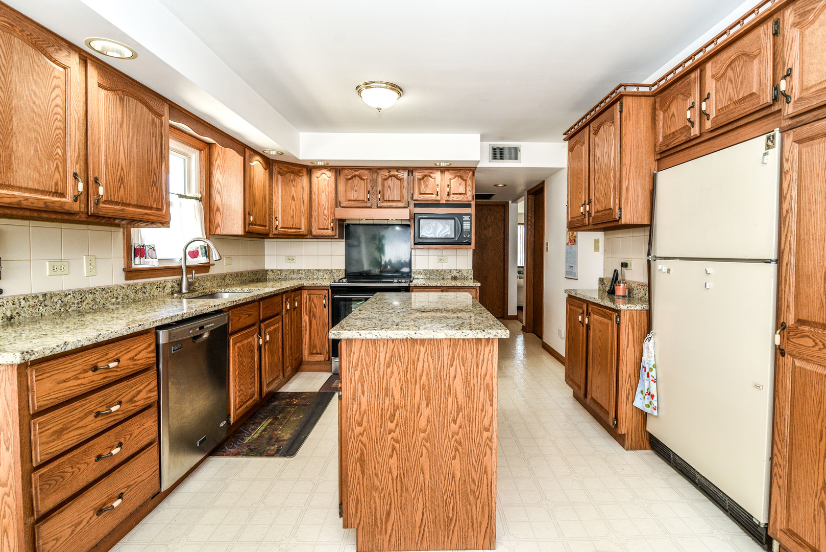 5149 State Road Burbank, IL 60459 - Photo 9 of 36 a kitchen with stainless steel appliances granite countertop a refrigerator a sink dishwasher a stove and white countertops with wooden floor