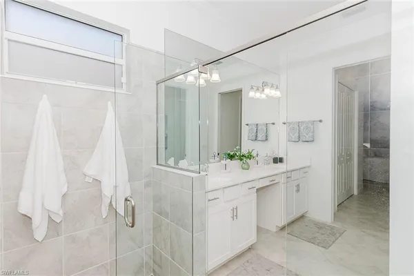 a bathroom with a double vanity sink mirror and shower