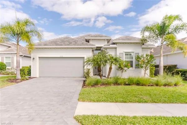 a front view of a house with a yard and a garage