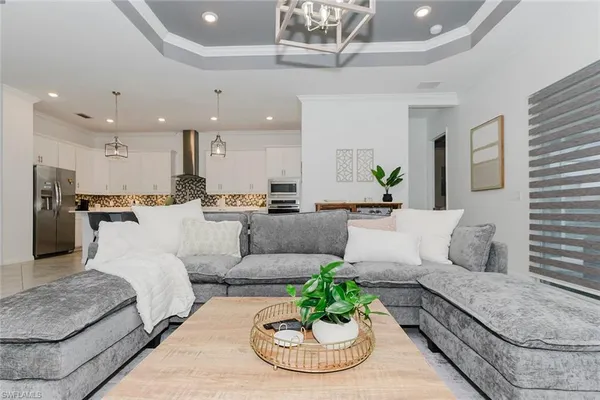 a living room with furniture kitchen and a chandelier