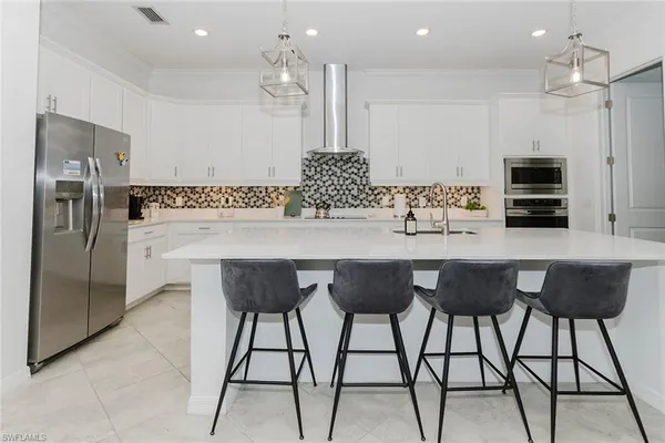 a kitchen with stainless steel appliances kitchen island granite countertop a refrigerator and a stove top oven