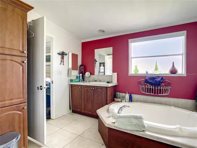 a spacious bathroom with a tub sink and mirror