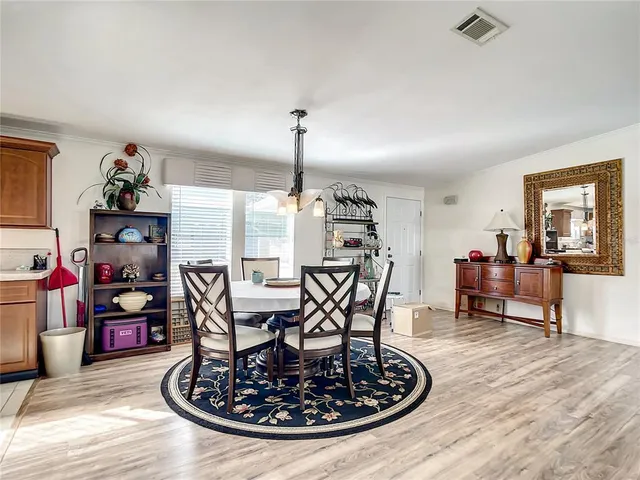 a view of a dining room and livingroom with furniture wooden floor a chandelier